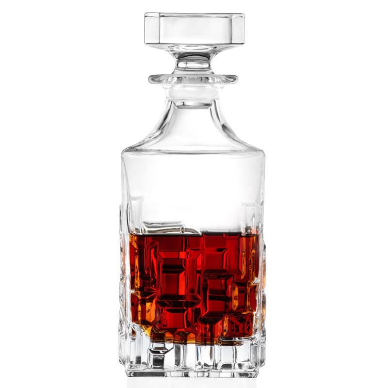 Eclectic RCR Etna crystal whisky decanter with geometric cut pattern and amber liquid, isolated on white background