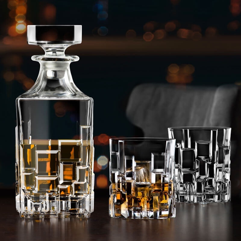 Eclectic RCR Etna 7-piece crystal whisky decanter and tumbler set with geometric cut patterns and amber spirits.