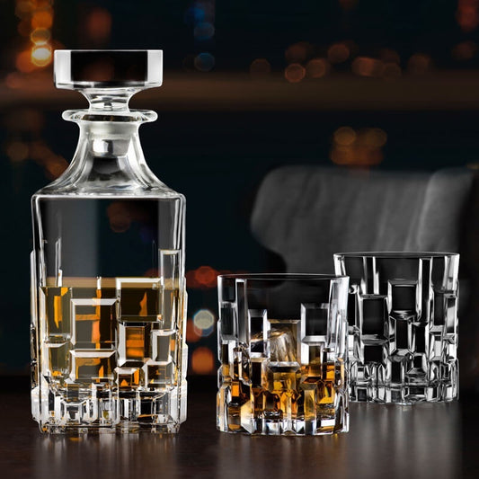 Eclectic RCR Etna 7-piece crystal whisky decanter and tumbler set with geometric cut patterns and amber spirits.