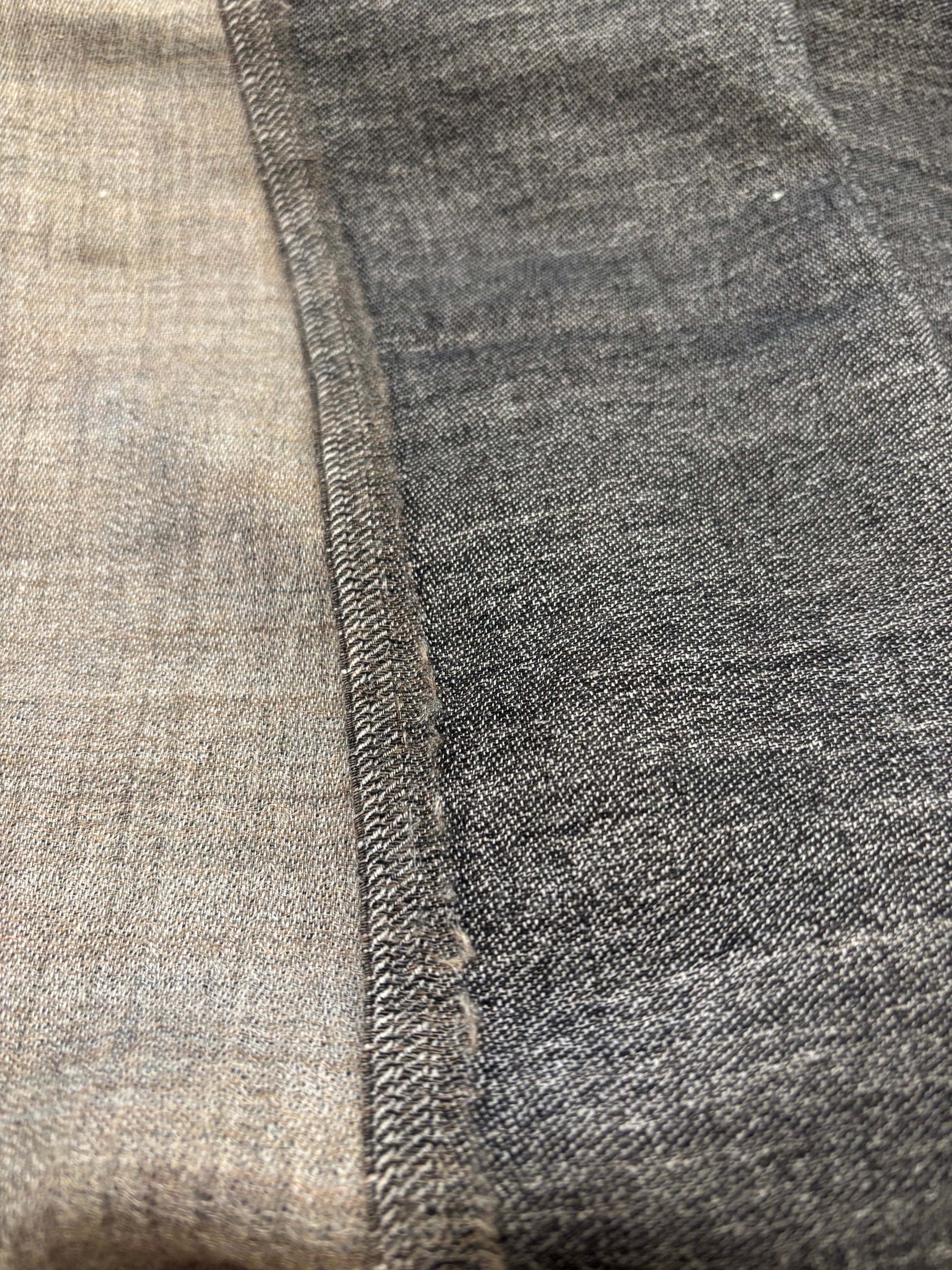 Eclectic reversible cashmere scarf showing a close-up of the grey and charcoal textured fabric seam.