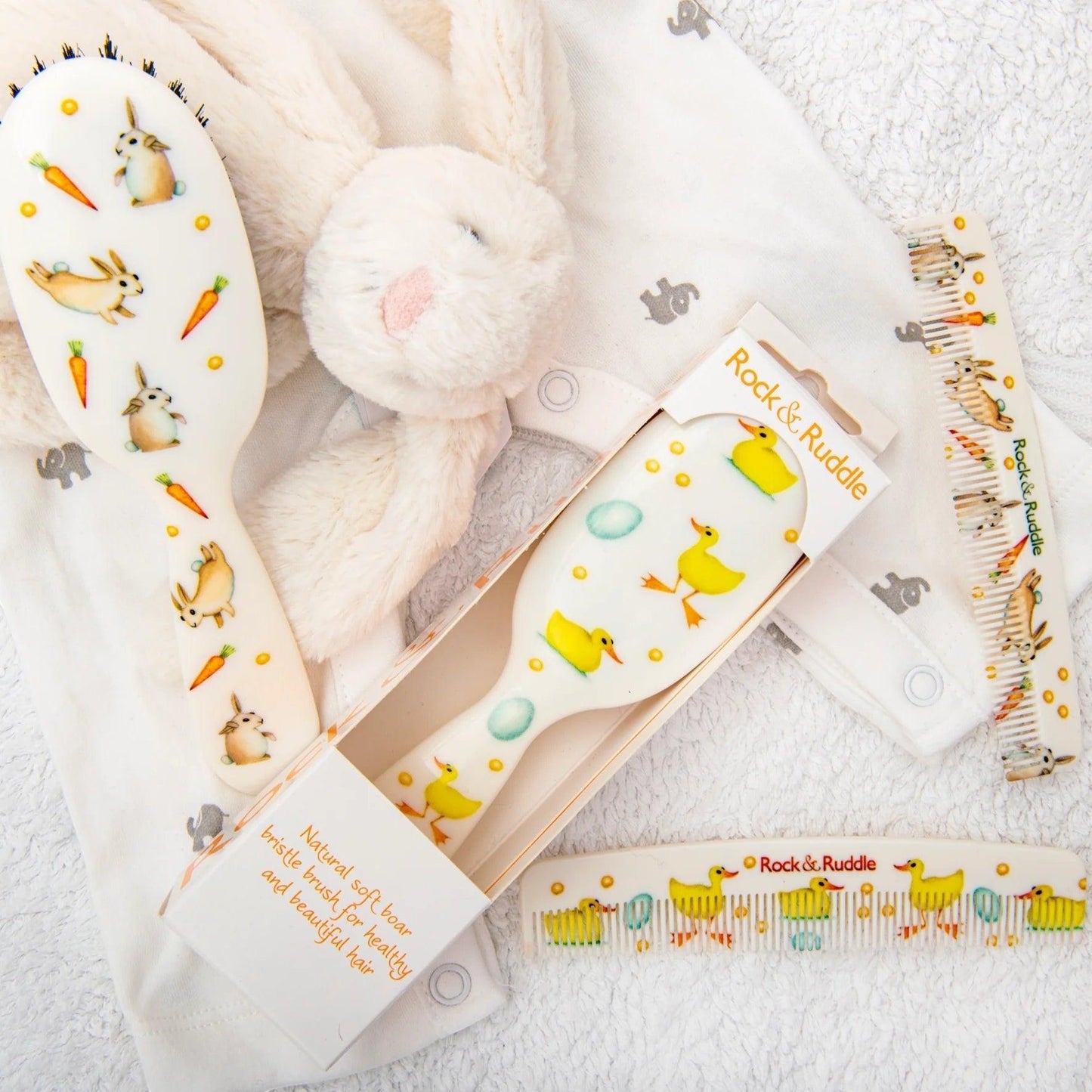 Eclectic Rock & Ruddle baby hairbrushes and combs featuring charming rabbit and duck illustrations on white handles.