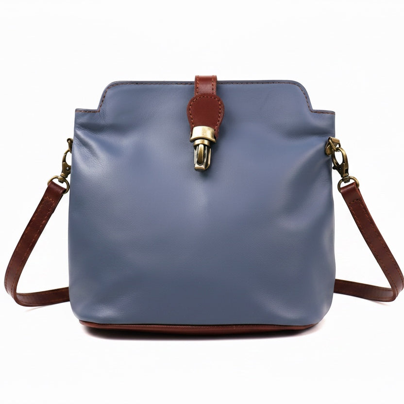 Eclectic Roma leather crossbody bag in blue with tan trim, gold hardware, and a decorative buckle detail.