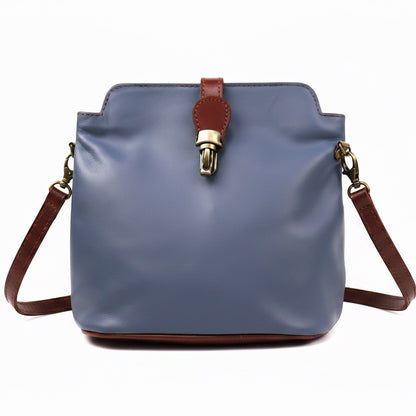Eclectic Roma leather crossbody bag in blue with tan trim, gold hardware, and a decorative buckle detail.