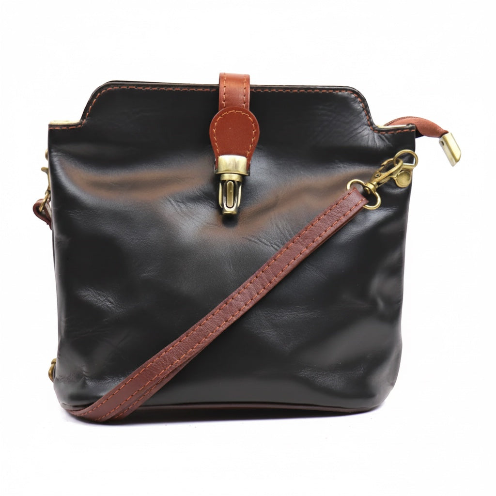 Eclectic Roma leather crossbody bag in black with tan trim, gold hardware, and a decorative buckle detail.