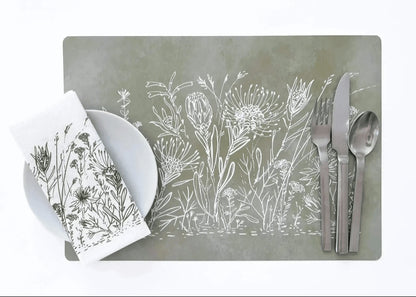Eclectic sage green reusable placemat with white botanical fynbos illustration, set with cutlery and a matching napkin.