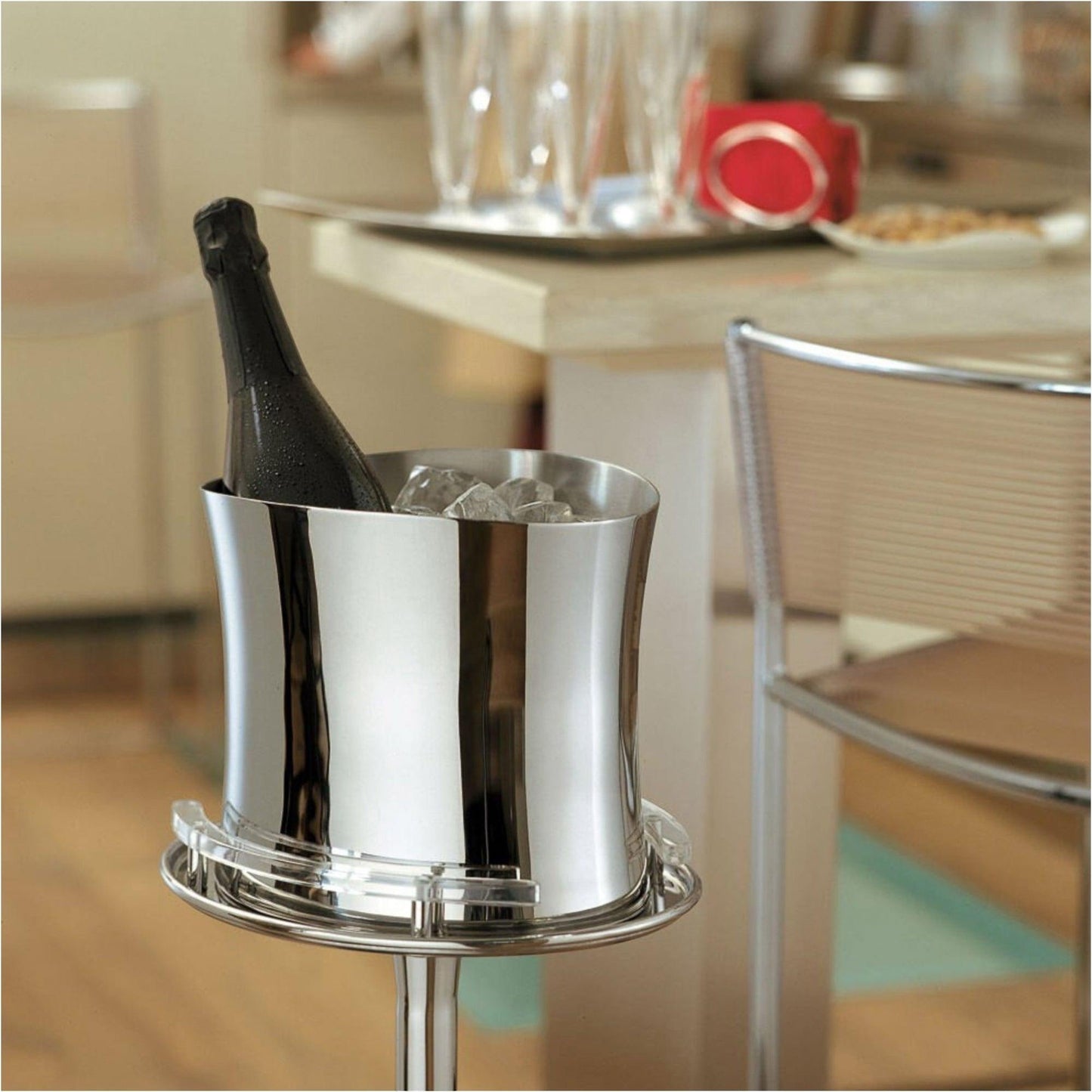 Eclectic Sambonet Bamboo mirror-polished stainless steel wine cooler holding a bottle of champagne on a stand.