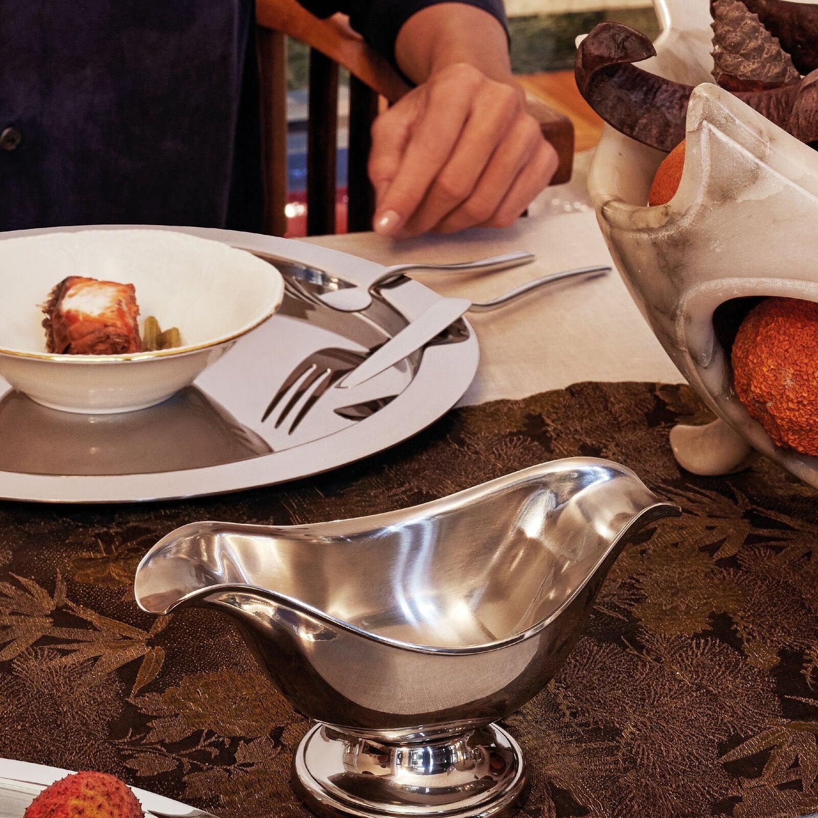 Eclectic Sambonet Elite oval sauce boat in mirror-polished stainless steel on a formal dining table setting.