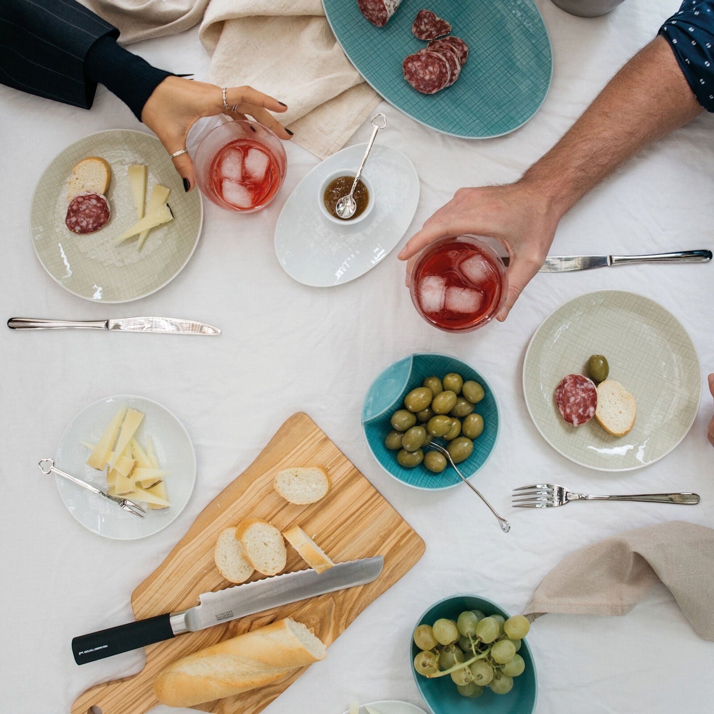 Eclectic Sambonet Party Portafortuna mirror stainless steel spoons on a dining table with appetizers and drinks