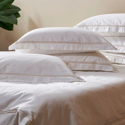 Eclectic Saxon white cotton sateen duvet set with elegant stone-coloured double satin stitch detail on pillows.