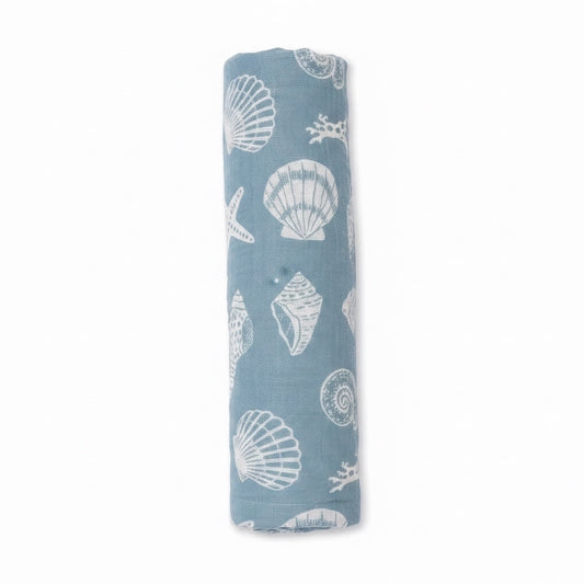 Eclectic Seaside Shells cotton muslin swaddle in seafoam green with white shell print, rolled for display.