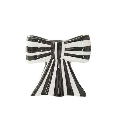 Eclectic black and white striped ceramic bow-shaped taper candle holder with a smooth glazed finish.