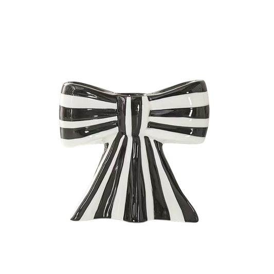 Eclectic black and white striped ceramic bow-shaped taper candle holder with a smooth glazed finish.