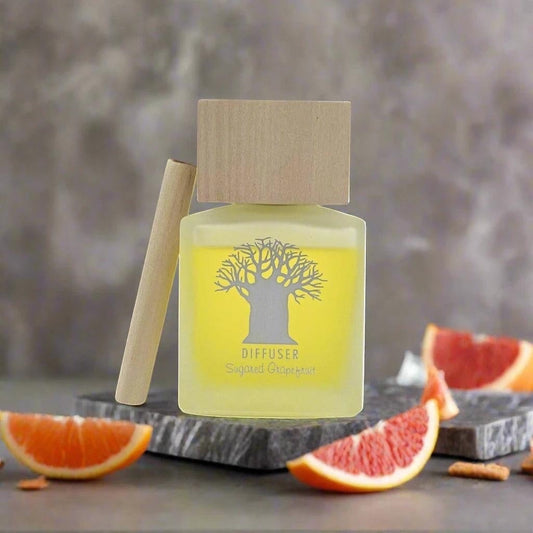 Eclectic Sugared Grapefruit diffuser in a frosted glass bottle with a natural wooden lid and tree logo design.