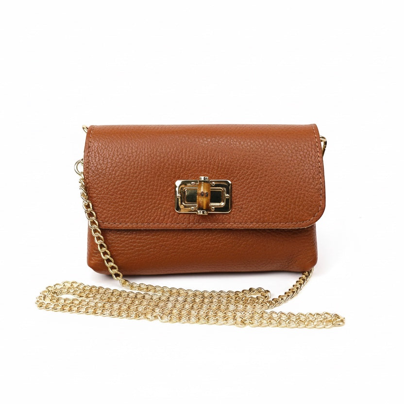 Eclectic tan pebbled leather clutch with a bamboo-inspired gold clasp and detachable gold chain shoulder strap.