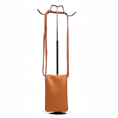 Eclectic genuine pebbled leather phone crossbody bag in tan with an adjustable strap hanging on a display stand.