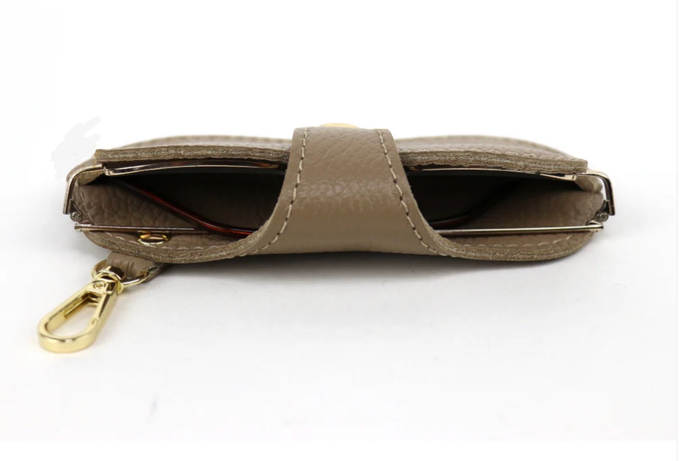Eclectic Italian leather glasses case in taupe with gold-tone clip and snap-button closure, top view.