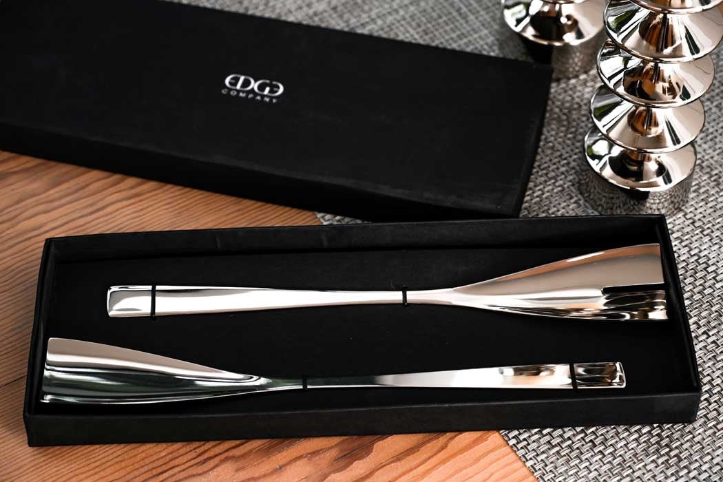 Eclectic Turin mirror polished stainless steel salad servers presented in a sleek black gift box on a wooden table.