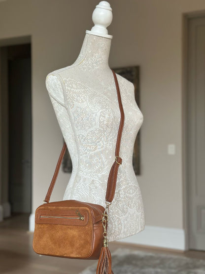 Eclectic Venezia tan suede and leather crossover bag with tassels and adjustable strap on a mannequin