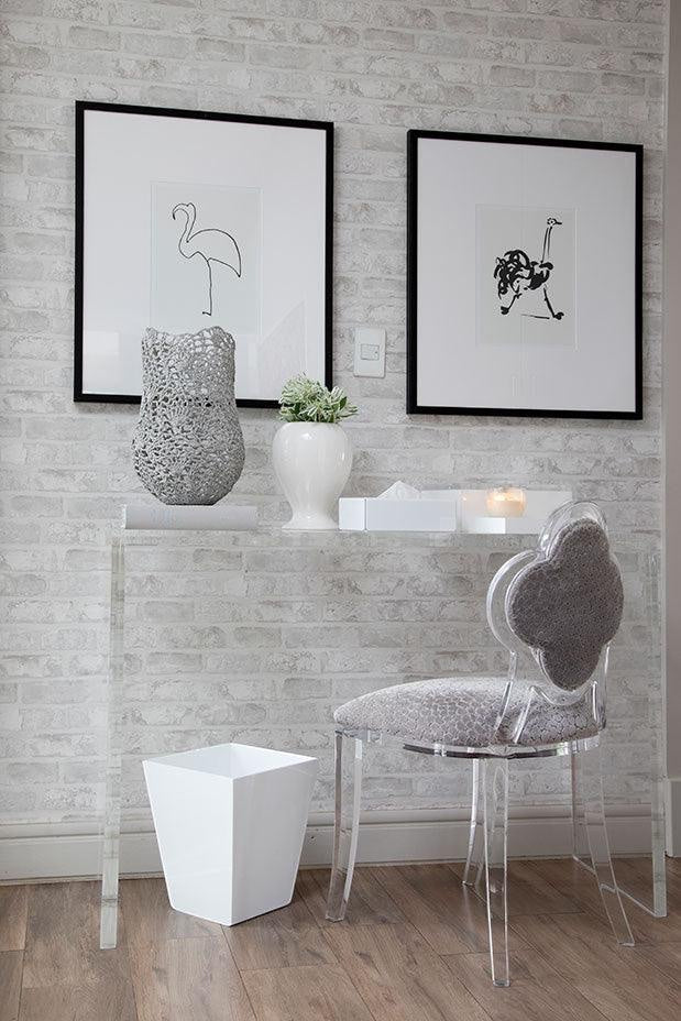 Eclectic white square tapered acrylic dustbin placed under a modern glass console table in a minimalist home office.