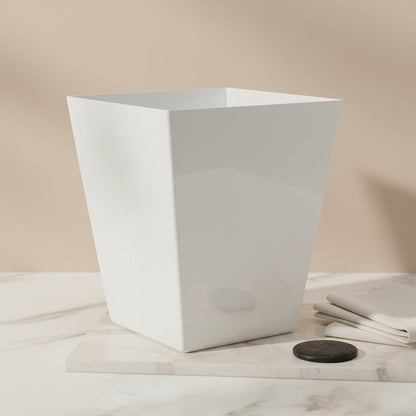 Eclectic white square tapered acrylic dustbin on a marble surface in a minimalist room setting.