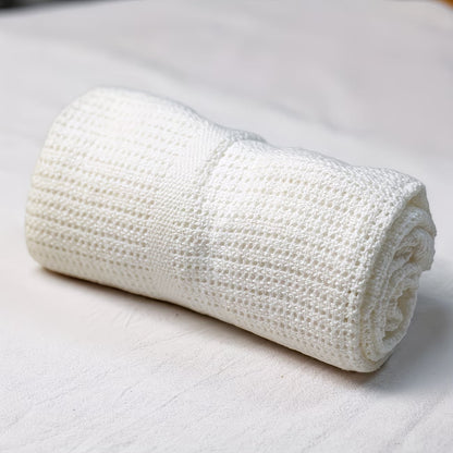 Eclectic white 100% cotton cellular baby blanket with a breathable knit texture for nursery use.