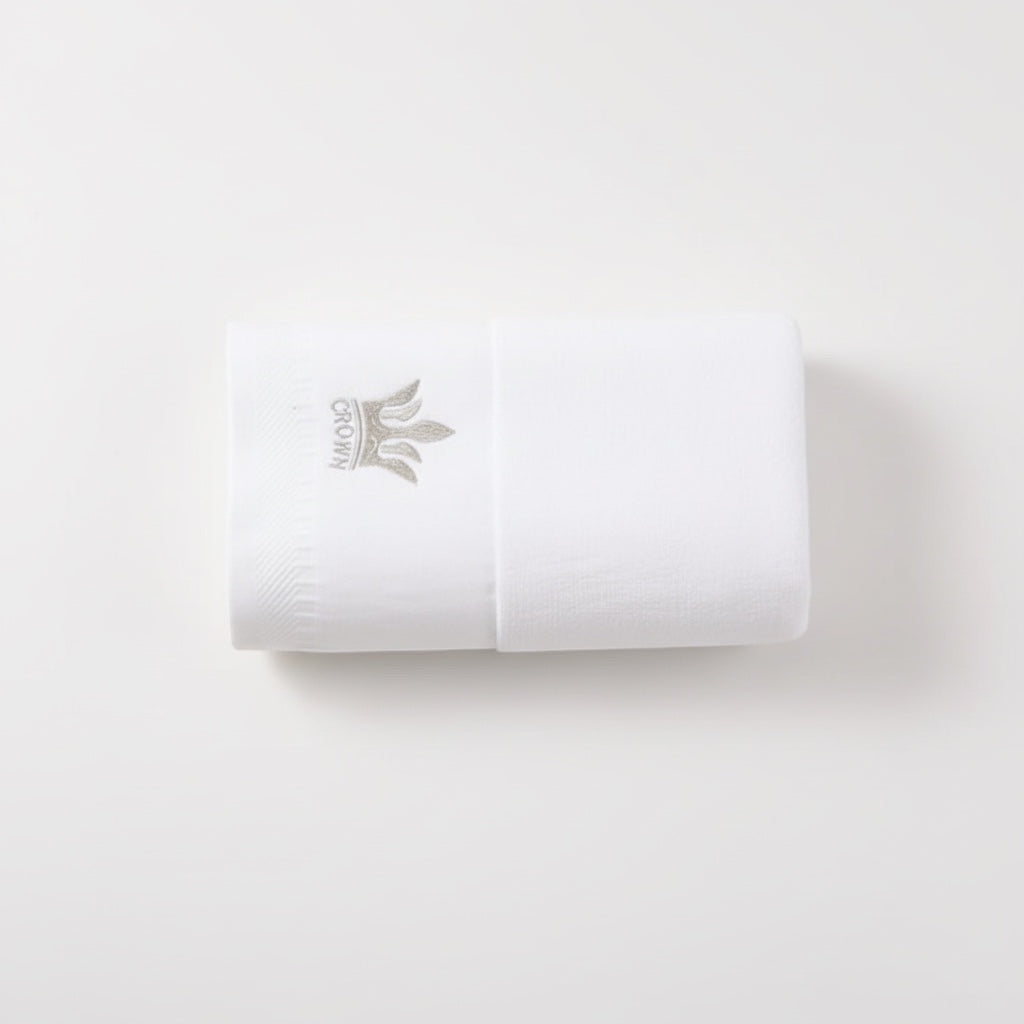 Eclectic white cotton guest towel featuring an elegant embroidered crown detail on a soft 400 gsm fabric.