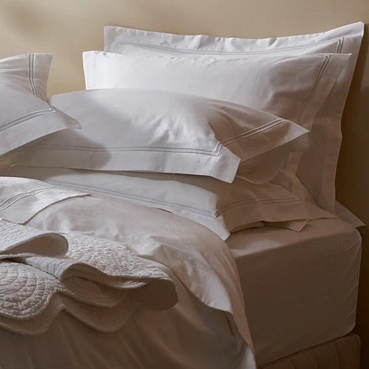 Eclectic white 300TC Egyptian cotton sateen fitted sheet on a neatly made bed with matching pillows