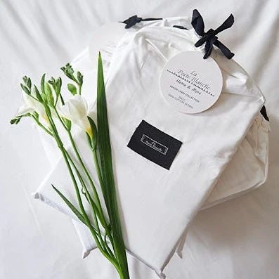 Eclectic white 300TC Egyptian cotton sateen fitted sheet in elegant fabric packaging with fresh white flowers