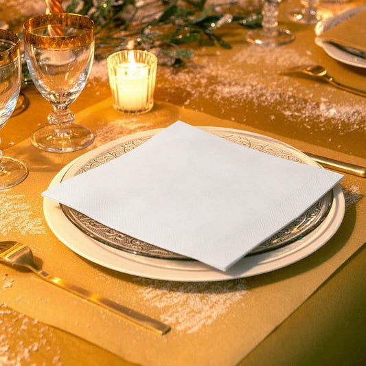 Eclectic white airlaid linen-feel disposable napkin folded on a decorative plate at a formal table setting