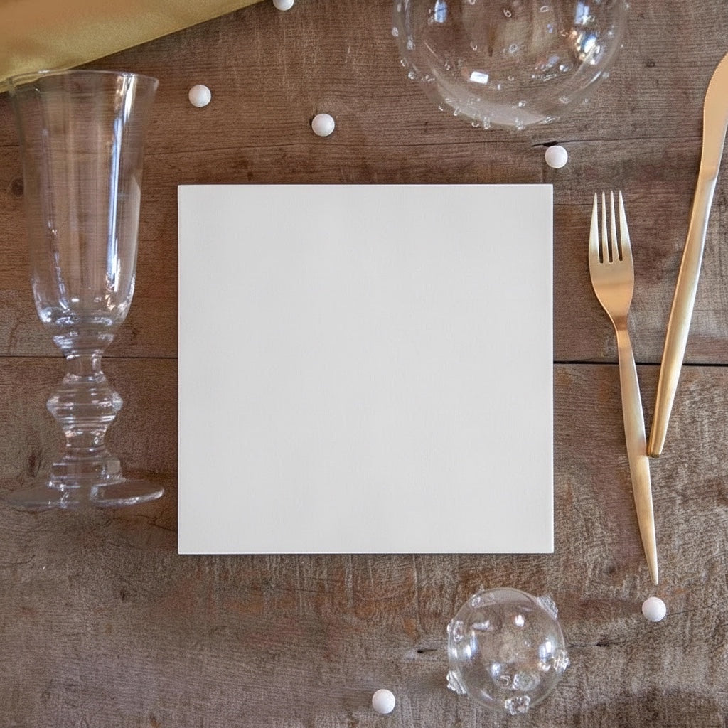 Eclectic white linen-feel airlaid napkin on a rustic wooden table with gold cutlery and glassware