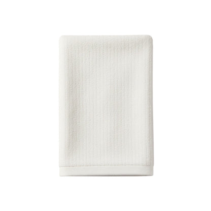 Eclectic white velvet cotton guest towel with a soft, absorbent texture for a luxurious bathroom aesthetic.