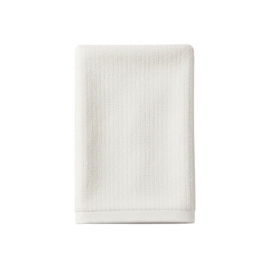 Eclectic white velvet cotton guest towel with a soft, absorbent texture for a luxurious bathroom aesthetic.
