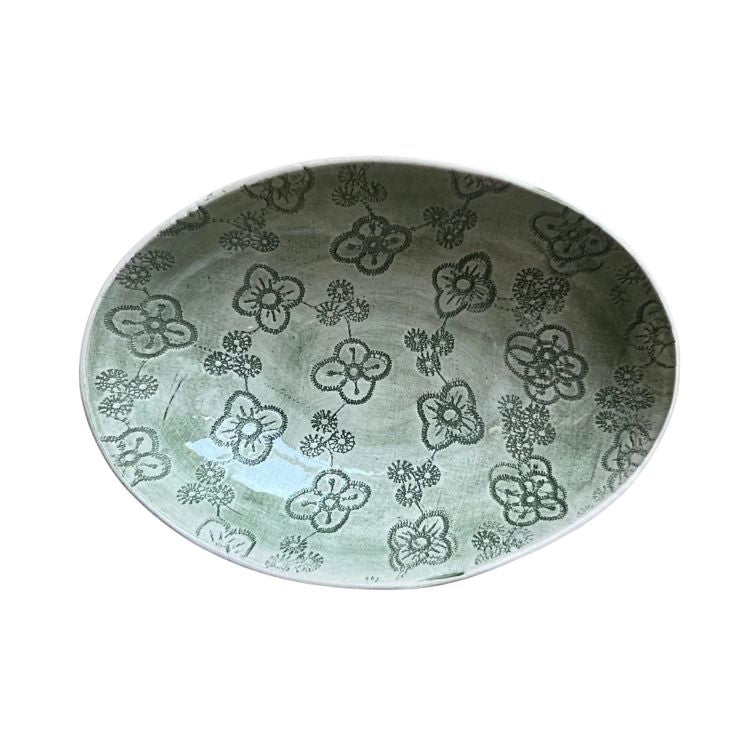 Eclectic Wonki Ware oval stoneware bowl in green with a hand-painted floral pattern, top-down view.