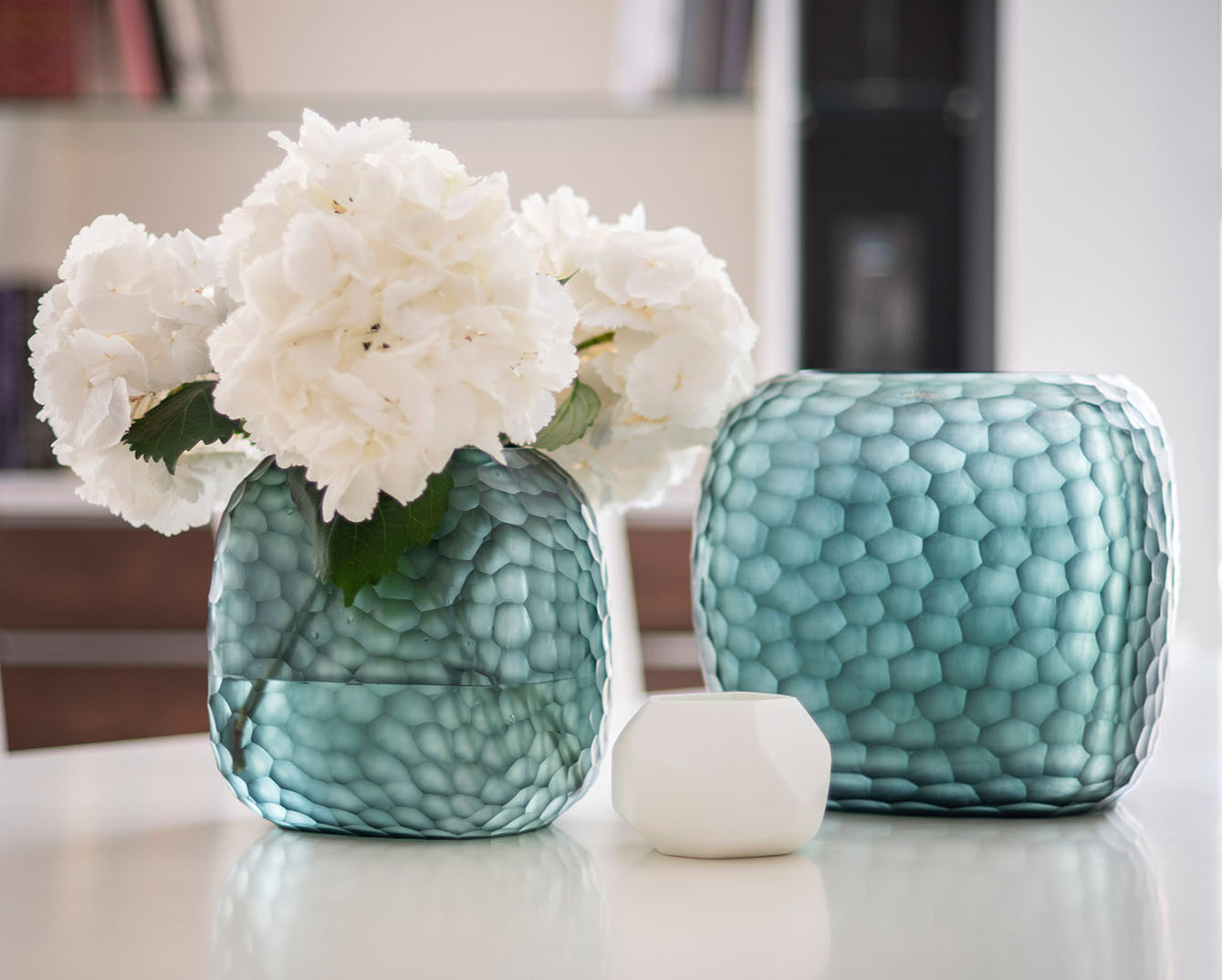 Guaxs vase collection with textured glass vases and flowers.