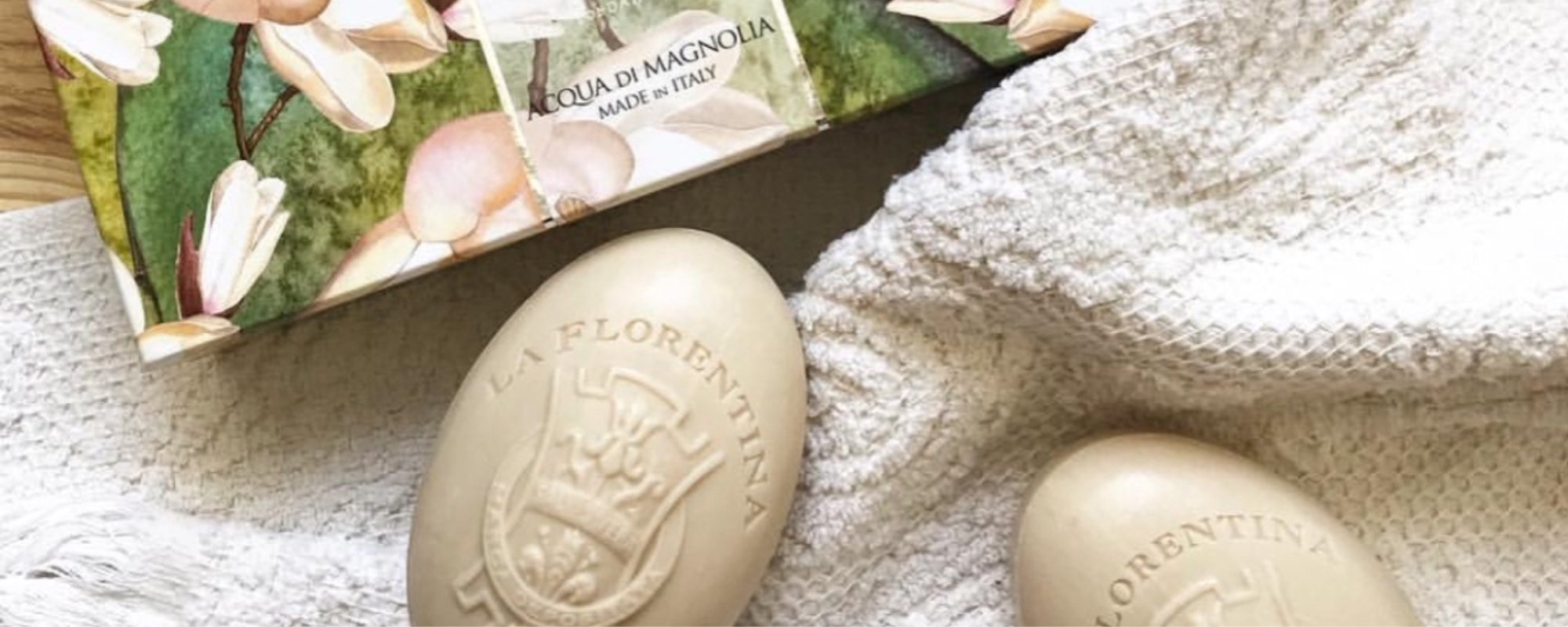 Scented soaps and handwash products styled with a towel and floral packaging.