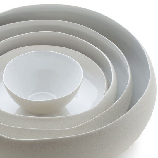 Médard de Noblat white tableware collection with stacked bowls and plates.